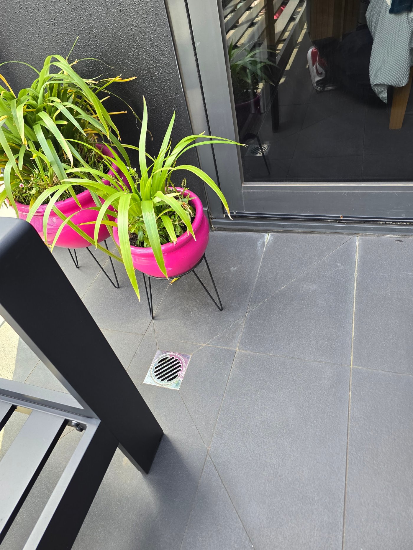 Tiled apartment balcony with floor drain before remedial waterproofing works