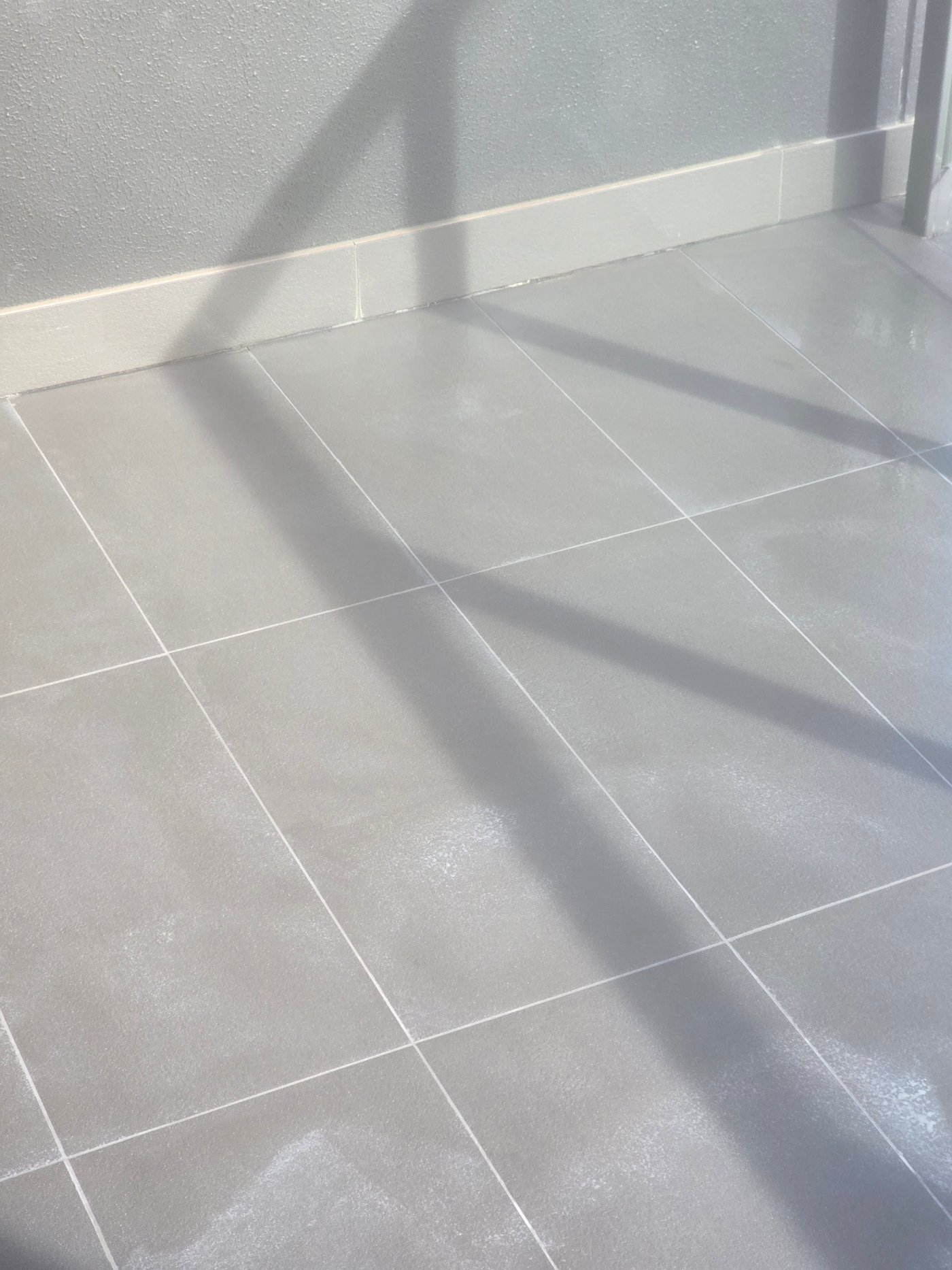 Fresh epoxy grout applied across the tile joints of an apartment balcony
