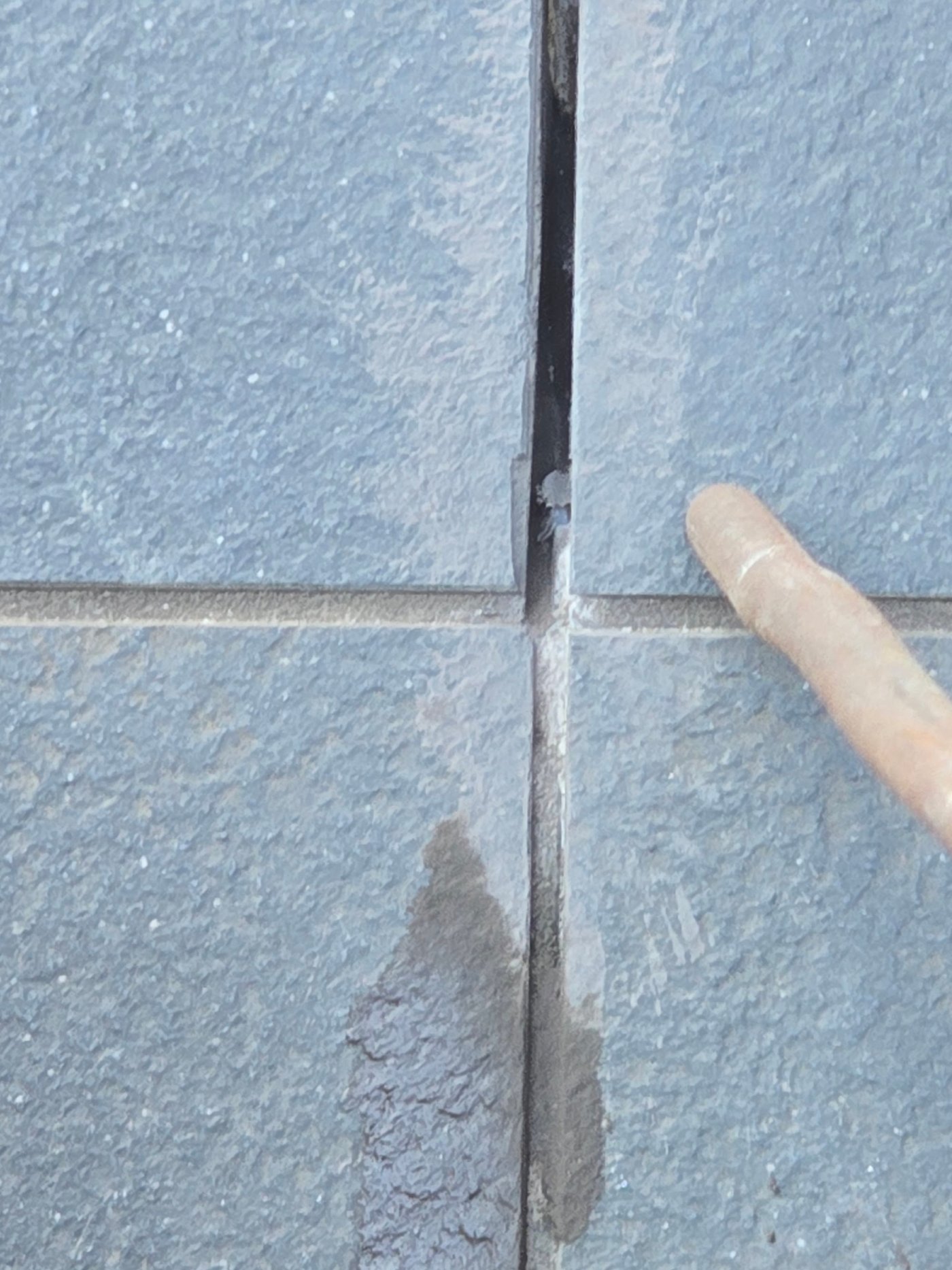 Old grout being cut out of the tile joints on an apartment balcony
