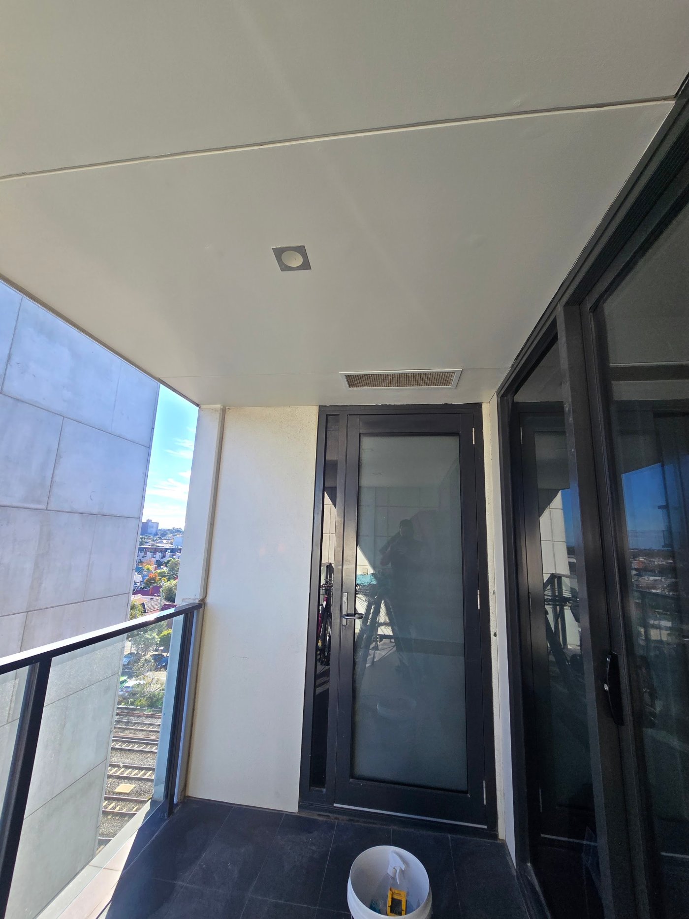 Finished painted ceiling below the repaired balcony with no sign of water damage
