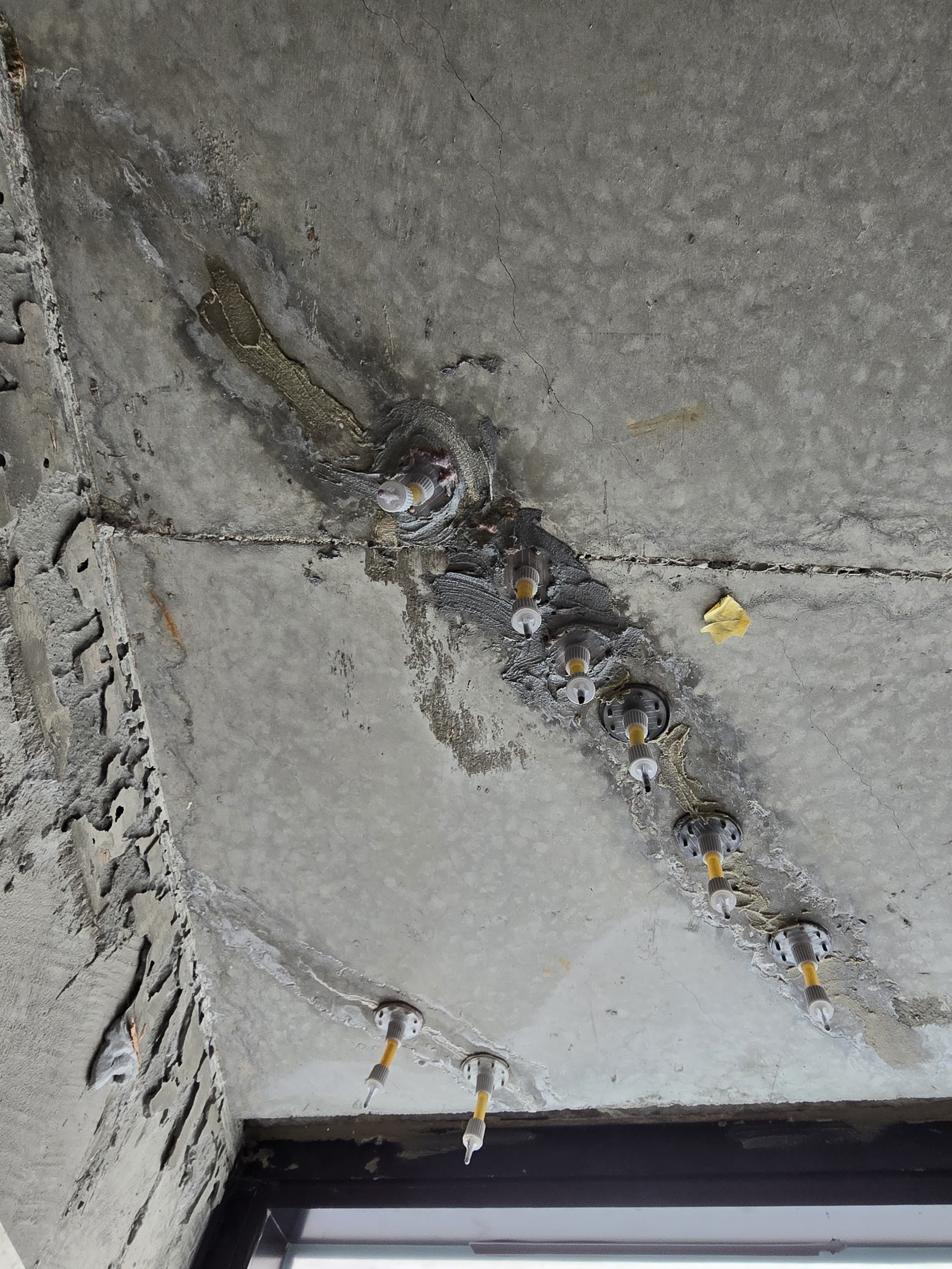 Helical crack stitching anchors installed in a cracked slab edge